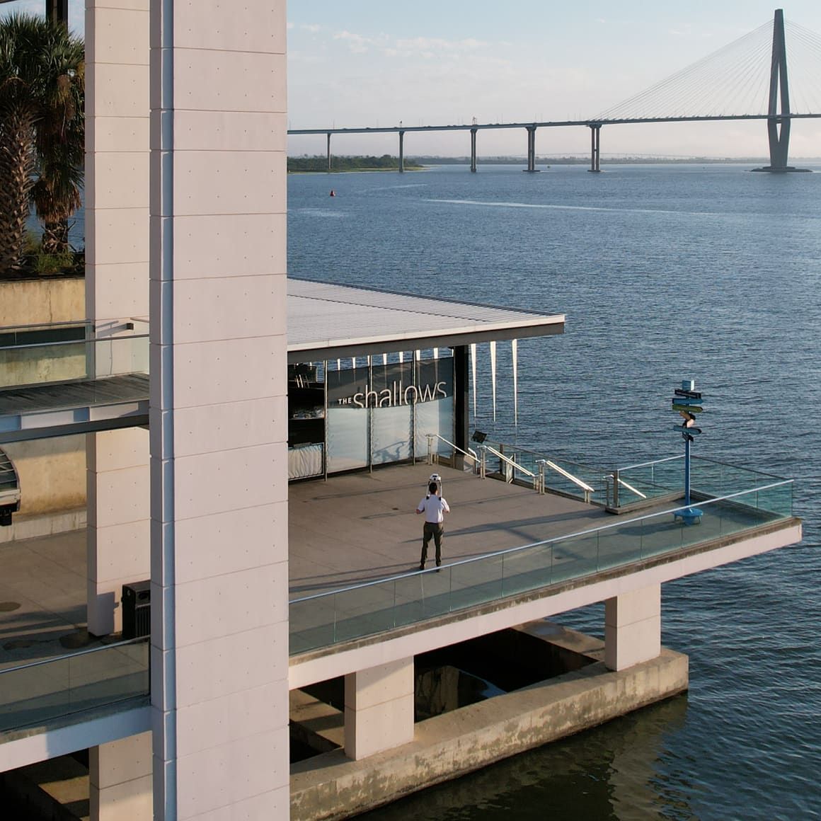 Field operator capturing site data with a handheld scanner over Charleston harbor